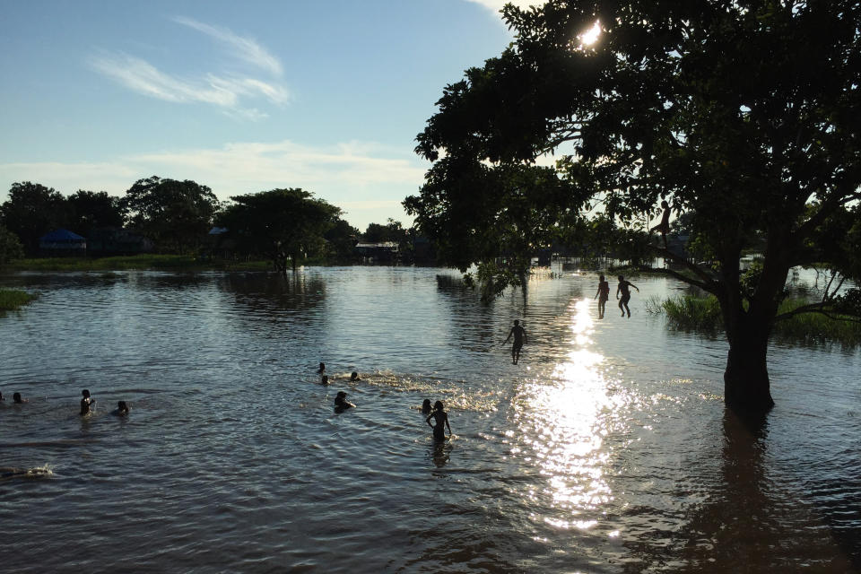 Children play in a flooded area of Leticia, Colombia, Feb. 14, 2017, located by the Amazon river, in the border with Brazil and Peru. Gustavo Petro, Colombia's first elected leftist president, will take office in August with ambitious proposals to halt the record-high rates of deforestation in the Amazon. (AP Photo/Fabiano Maisonnave)