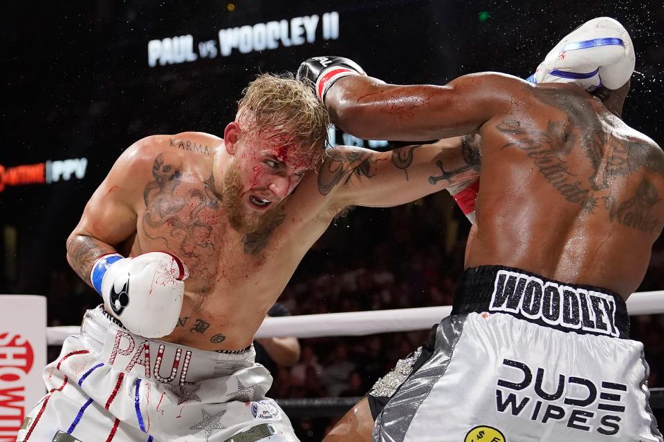 Jake Paul (left), hits Tyron Woodley with a punch during the third round of a cruiserweight boxing bout on Dec. 18, 2021, in Tampa, Fla. Paul's boxing match at Madison Square Garden next week has been canceled after his promotional team said opponent Hasim Rahman Jr. did not intend to honor the contracted weight limit.