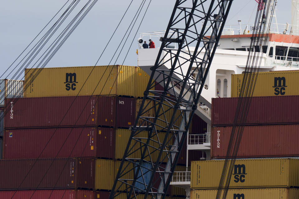 People are seen on the container ship Dali that lays under the collapsed Francis Scott Key Bridge lays, Thursday, April 25, 2024, in Baltimore. (AP Photo/Matt Rourke)