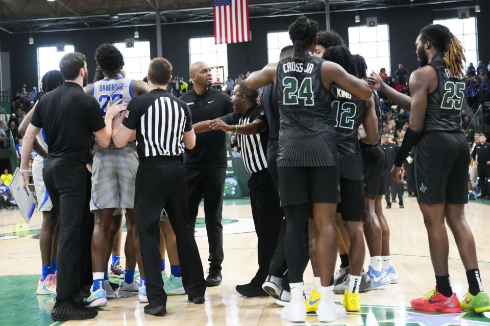 Referees breaks up a scuffle between Tulane and Memphis during the first half of an NCAA college basketball game in New Orleans, Sunday, Jan. 21, 2024. (AP Photo/Gerald Herbert)