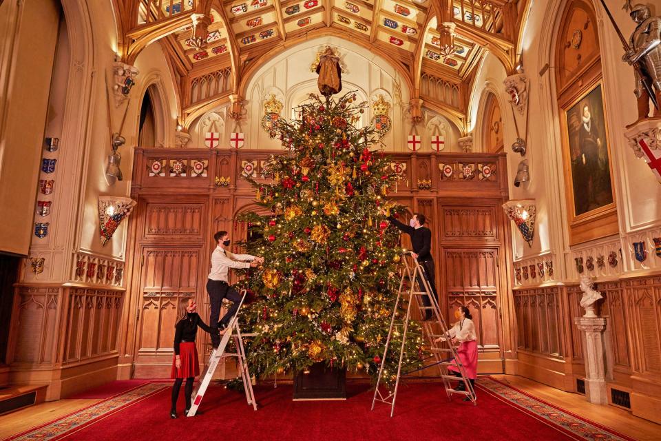 <p>Royal Collection Trust staff decorate the 20-foot-high Christmas tree in St George's Hall, the largest room in Windsor Castle</p>PA