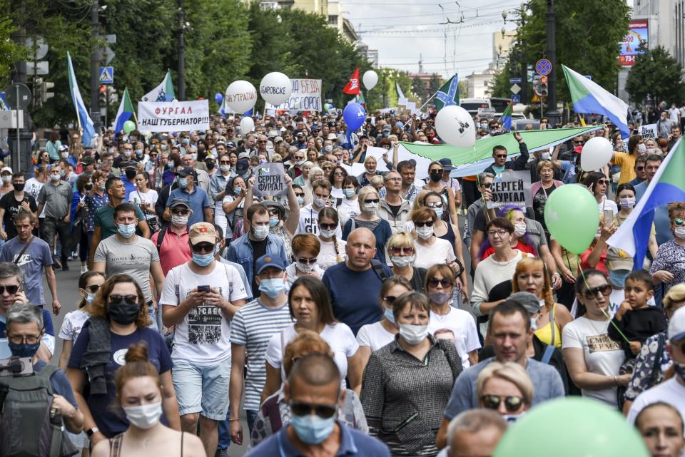 People hold posters that read: "I am, We are Sergei Furgal, Sergei Furgal our Governor", during an unsanctioned protest in support of Sergei Furgal, the governor of the Khabarovsk region, in Khabarovsk, 6100 kilometers (3800 miles) east of Moscow, Russia, Saturday, Aug. 8, 2020. Thousands of demonstrators have again gathered in the major Russian Far East city of Khabarovsk to denounce the arrest of the region's governor a month ago. Sergei Furgal was arrested on suspicion of involvement in murders and taken to jail in Moscow. The estimated 3,000 demonstrators in Khabarovsk protested the charges and want him returned to the city for trial. (AP Photo/Igor Volkov)