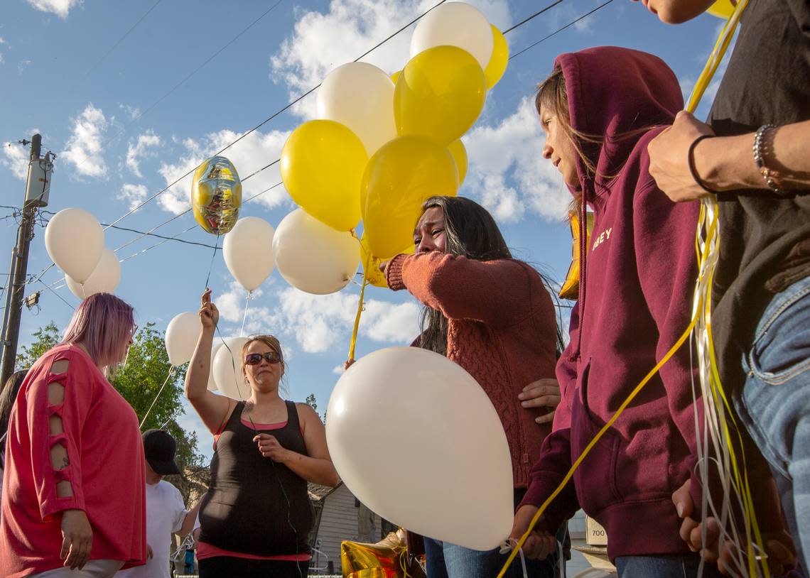 File -- Janet Nunez cries as she holds some balloons while surrounded by friends and family at a memorial ceremony for her daughter Andrea who was shot and killed in 2019.