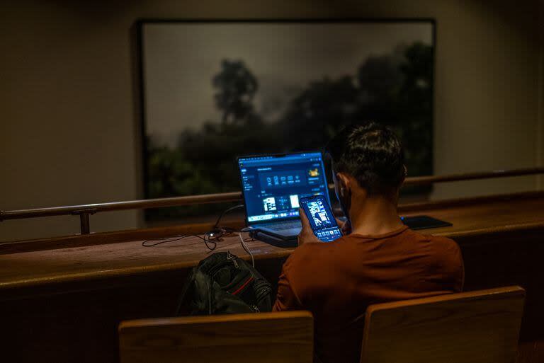 Un hombre trabaja con su computadora en un bar de Medellín

