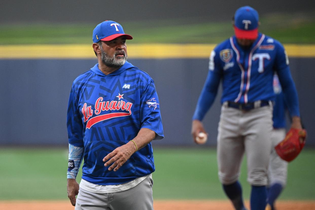 El manager de Tiburones de la Guaira, Oswaldo Guillén (L), camina hacia el montículo del lanzador durante el partido de la Liga Venezolana de Béisbol entre Leones del Caracas y Tiburones de la Guaira en el Estadio Monumental Simón Bolívar de Caracas, el 7 de enero de 2024. (Foto de FEDERICO PARRA/AFP vía Getty Images)