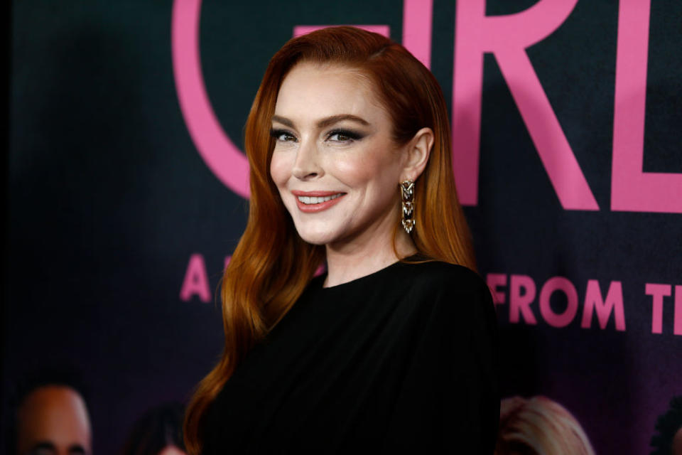 Lindsay at an event wearing a black dress and dangle earrings