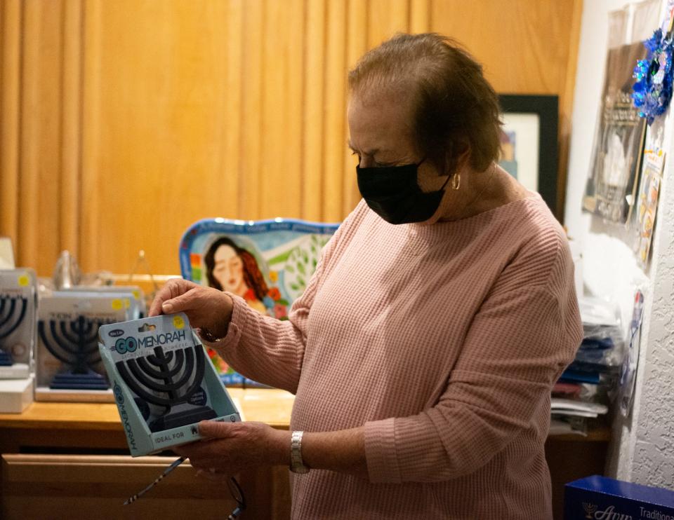 Linda Lewensohn displays a menorah for sale in the gift shop of Temple Isaiah in Palm Springs, Calif., on November 28, 2021.