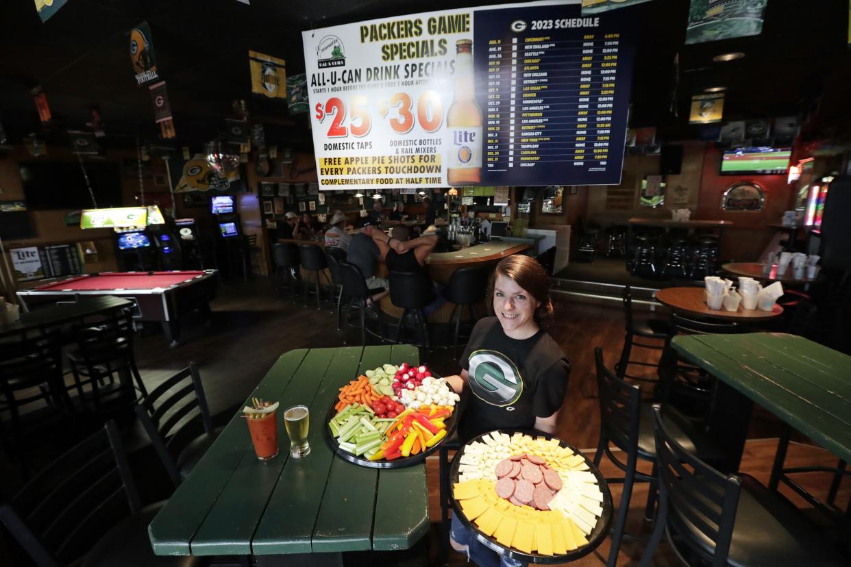 Bartender Rachel Janssen shows off a cheese and sausage platter along with a veggie platter that are onsite during Green Bay Packers games. She is pictured in the front seating area of Emmett's Bar and Grill located at 139 N. Richmond Street Wednesday, October 4, 2023, in Appleton, Wis. The establishment offers a variety of food and drink specials during the games.