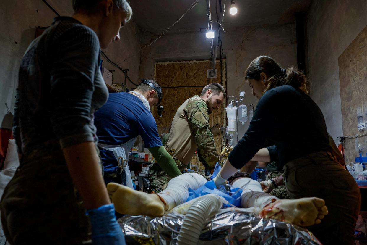 Medics of the 47th 'Magura’ Separate Mechanised Brigade help a Ukrainian serviceman, who was recently wounded in the town of Avdiivka (REUTERS)