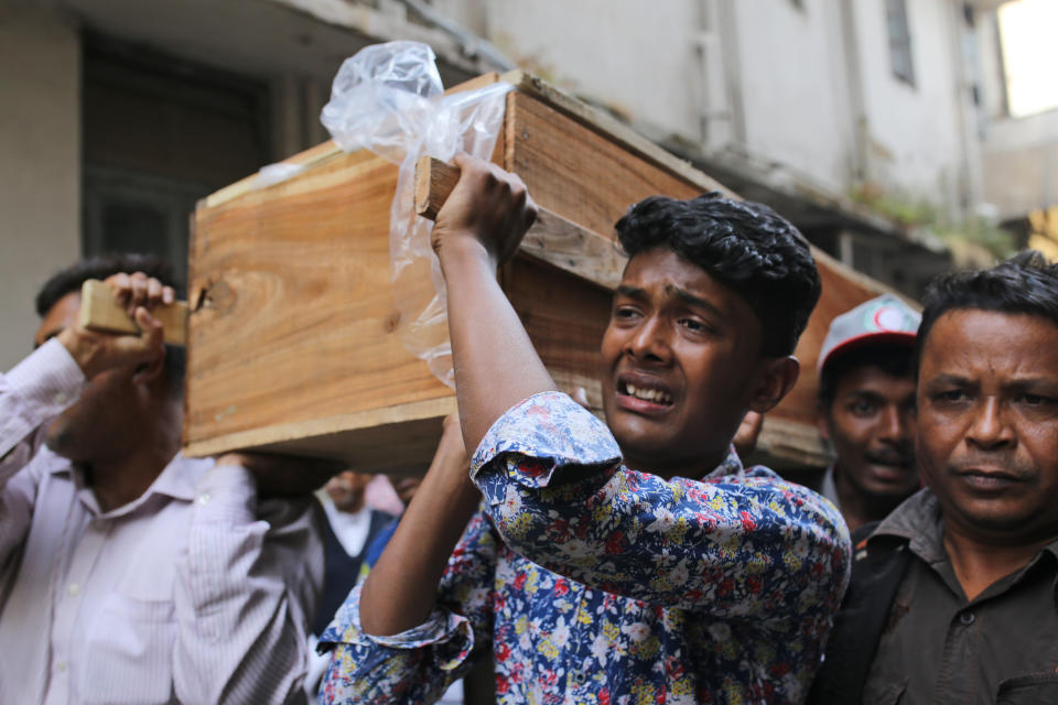 A Bangladeshi boy cries as he carries the coffin of a relative who died in a fire in Dhaka, Bangladesh, Thursday, Feb. 21, 2019. A devastating fire raced through at least five buildings in an old part of Bangladesh's capital and killed scores of people. (AP Photo/Rehman Asad)