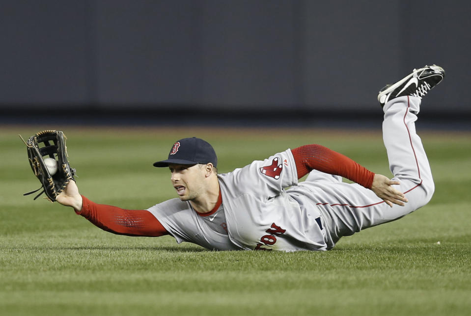 Boston Red Sox right fielder Daniel Nava shows the ball to the umpire after making a sliding catch on a third-inning fly-out hit by New York Yankees' Yangervis Solarte in a baseball game at Yankee Stadium in New York, Thursday, April 10, 2014. (AP Photo/Kathy Willens)