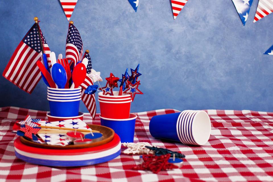 the tabletop setting, blue background, checker tablecloth of red white and blue American culture celebration party