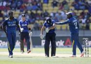 Sri Lanka's Mahela Jayawardene (R) pats England's James Taylor on the back after Taylor collided with Sri Lanka's Angelo Mathews (L) during their Cricket World Cup match in Wellington, March 1, 2015. REUTERS/Anthony Phelps