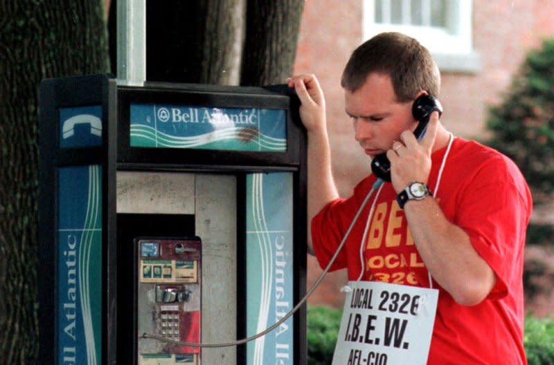 Mark Anderson, a Verizon line service technician, uses a pay phone outside the Verizon offices while picketing on the strike line August 8, 2000, in Battleboro, Vt. On August 13, 1889, William Gray patented the coin-operated telephone. File Photo by Steven E. Frischling/UPI