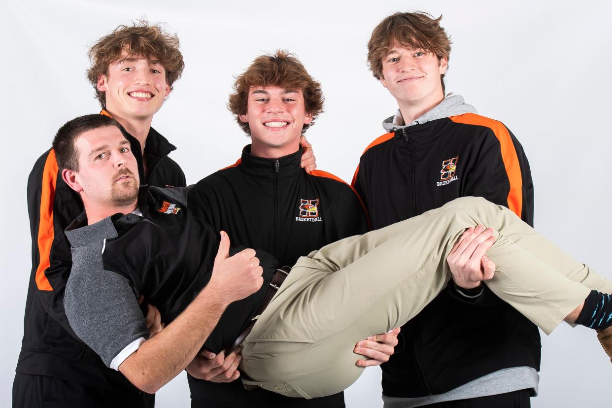 Hanover basketball head coach Kyle Krout (front) poses for a photo with players (from left) Ethan Killinger, Jaxon Dell and Ethan Herndon during YAIAA winter sports media days Wednesday, November 8, 2023, in York.