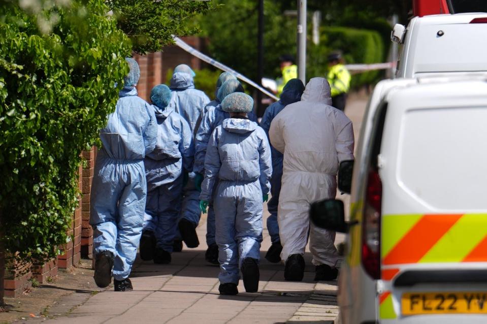 Forensic investigators at the scene in northeast London (PA)