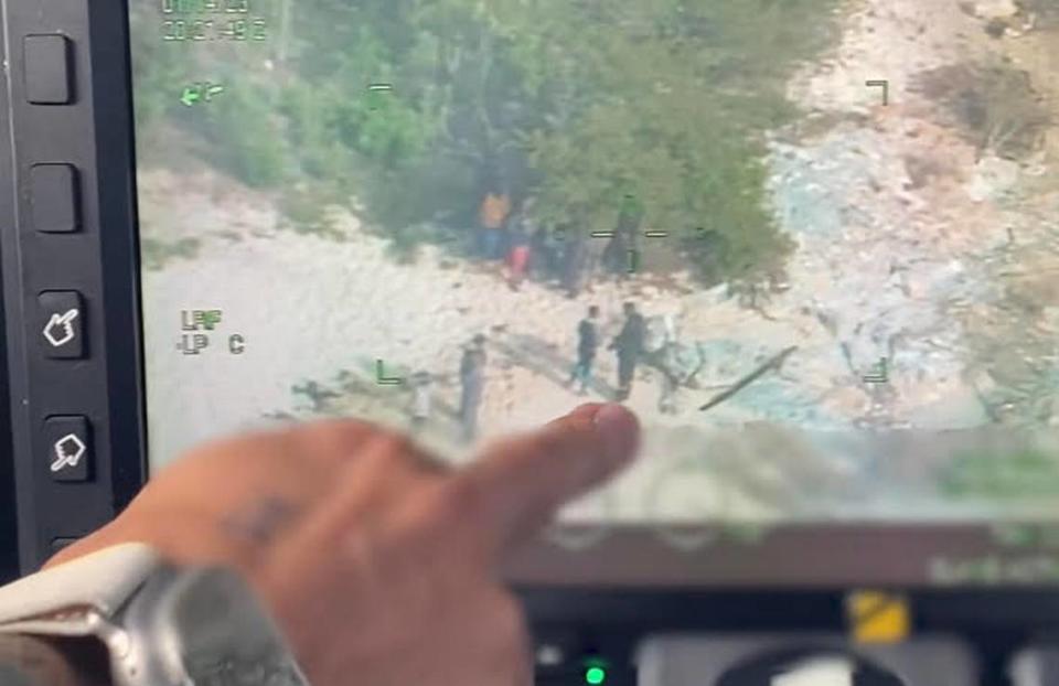 El teniente Spencer Zwenger, piloto de la Guardia Costera de Estados Unidos, señala una pantalla de video en la que aparecen personas sospechosas de ser migrantes en una remota playa de las Bahamas, el sábado 14 de enero de 2023.