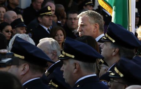 New York City Mayor Bill de Blasio (C) stands with other dignitaries outside the Christ Tabernacle Church following the funeral service for slain New York Police Department (NYPD) officer Rafael Ramos in the Queens borough of New York December 27, 2014. REUTERS/Mike Segar