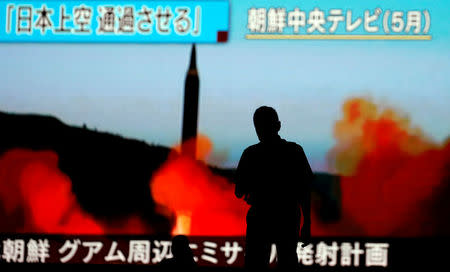 A man walks in front of a monitor showing news of North Korea's fresh threat in Tokyo, Japan, August 10, 2017. REUTERS/Toru Hanai