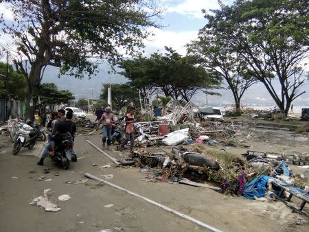 Resident checks dead bodies to find their family at a street after tsunami hit in Palu, Indonesia September 29, 2018. REUTERS/Stringer