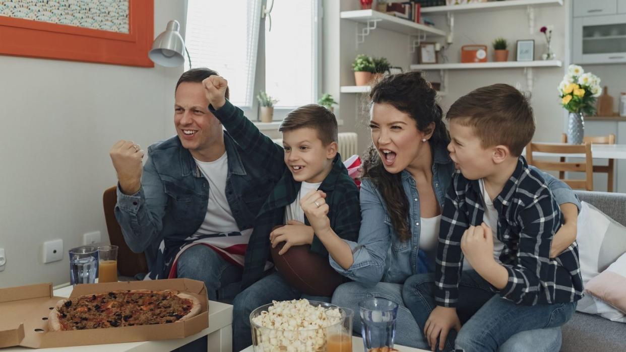 family watching sports on tv and cheering