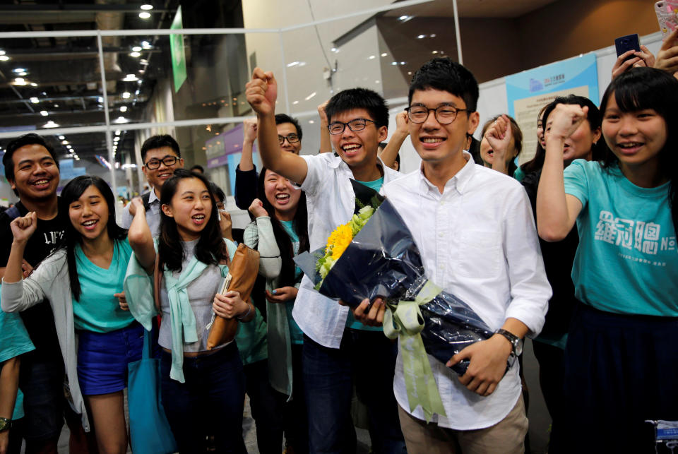 羅冠聰以港島區非建制票王姿態當選，成為立法會最年輕議員。林朗彥（左）及黃之鋒等一眾黨友在點票現場歡呼。圖片來源：路透社