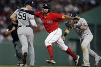 Boston Red Sox's Xander Bogaerts, center, is caught in a rundown by New York Yankees' Gleyber Torres, right, after Rafael Devers grounded into a double play during the fifth inning of a baseball game, Saturday, June 26, 2021, in Boston. (AP Photo/Michael Dwyer)