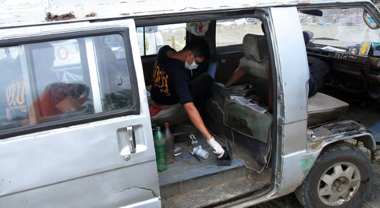 Philippine police investigators collect evidence inside a vehicle believed to have been used in the get-away by kidnappers of Italian national Rolando del Torchio, found abandoned in the city of Dipolog, southern island Mindanao, on October 8, 2015