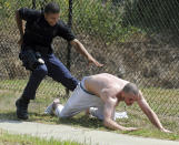 A police officer closes in to apprehend escaped jail inmate Thomas Julian Lopez in downtown Hattiesburg, Mississippi. Lopez had been jailed for grand larceny. Photo credit: AP