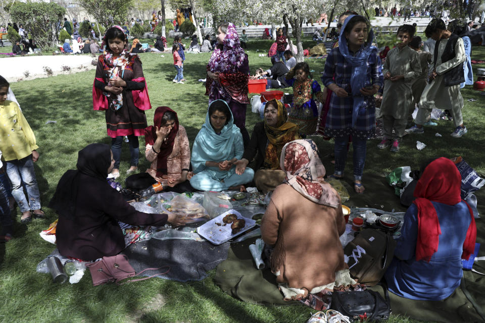 An Afghan family eat food at the park in Kabul, Afghanistan, Friday, April 9, 2021. (AP Photo/Rahmat Gul)