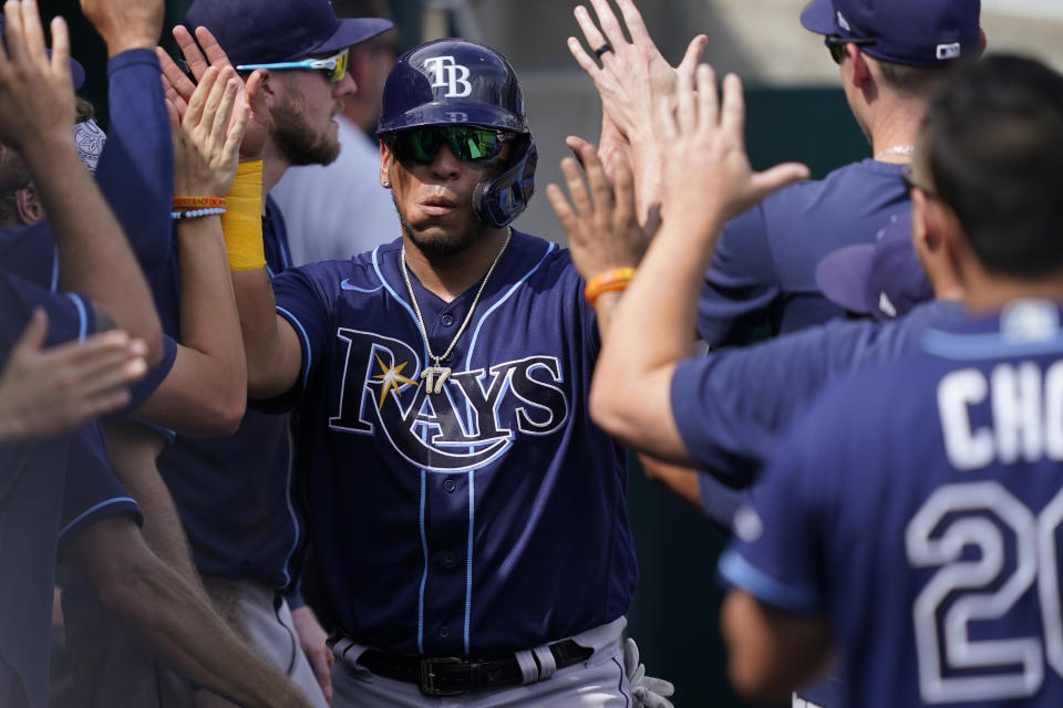 Tampa Bay Rays' Isaac Paredes is greeted in the dugout after scoring from third on a bases loaded walk to Yu Chang during the ninth inning of a baseball game against the Detroit Tigers, Sunday, Aug. 7, 2022, in Detroit. (AP Photo/Carlos Osorio)