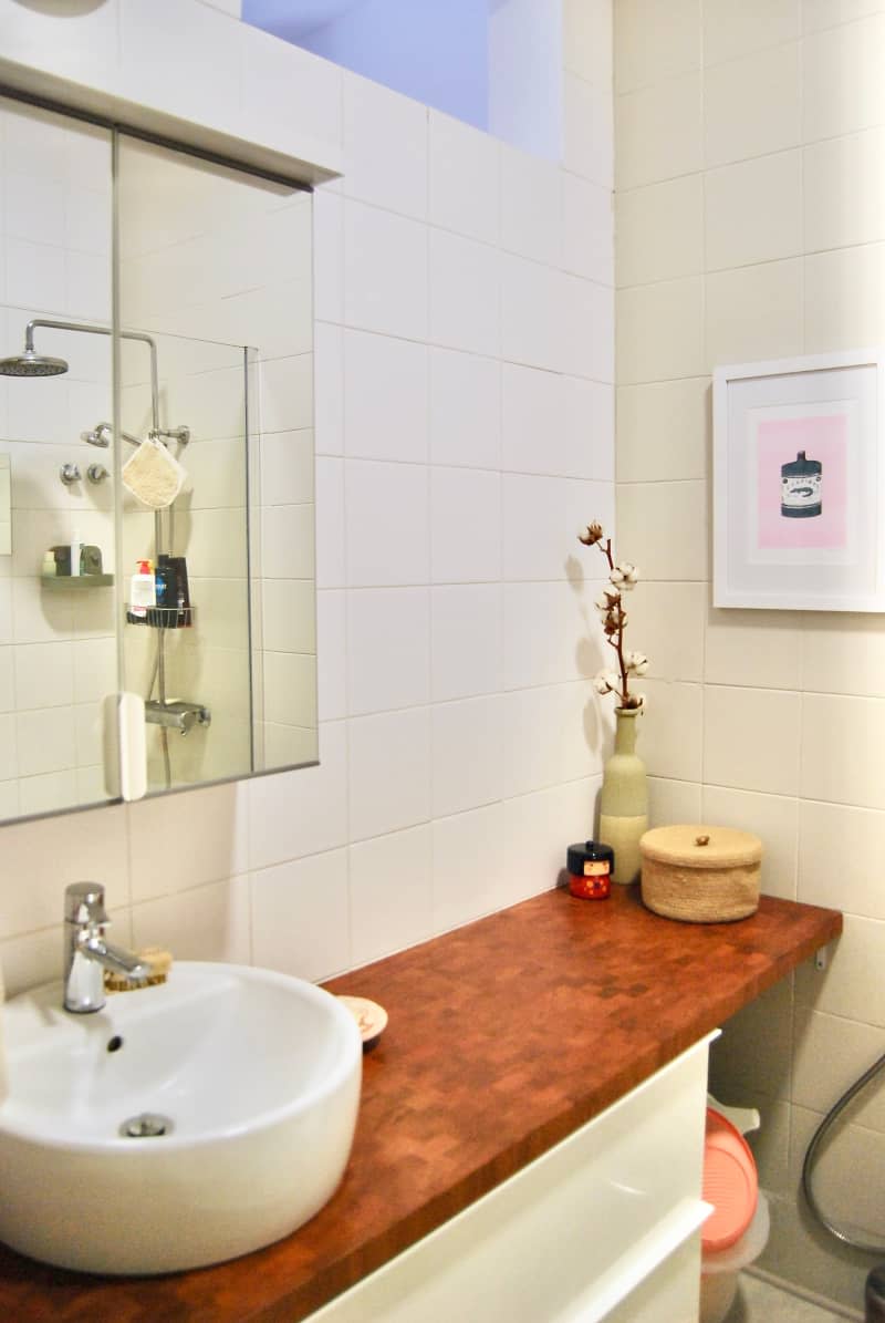 Wood vanity in white bathroom.