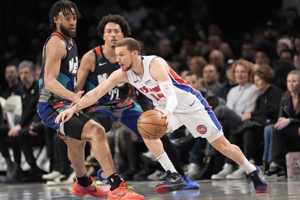 Detroit Pistons guard Malachi Flynn (14) controls the ball against Brooklyn Nets guard Lonnie Walker IV, left, and forward Jalen Wilson (22) during the first half of an NBA basketball game, Saturday, April 6, 2024, in New York. (AP Photo/Mary Altaffer)