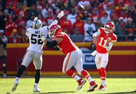 Dec 10, 2017; Kansas City, MO, USA; Kansas City Chiefs quarterback Alex Smith (11) throws a pass as Oakland Raiders defensive end Khalil Mack (52) defends in the first half at Arrowhead Stadium. Jay Biggerstaff-USA TODAY Sports