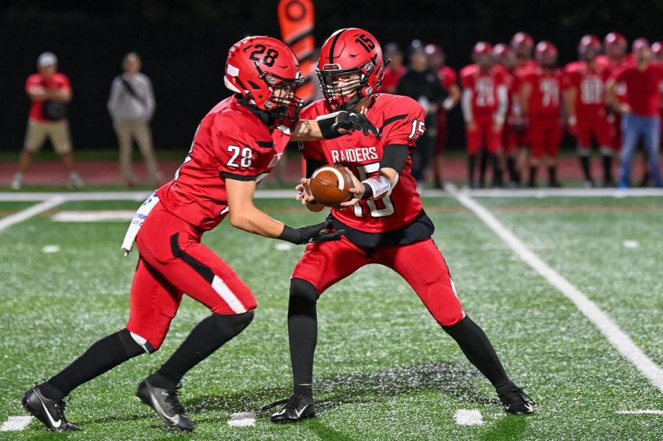 Bellefonte quarterback Liam Halterman hands off to Jackson Long during a game against Bald Eagle Area on Friday, Sept. 29, 2023.