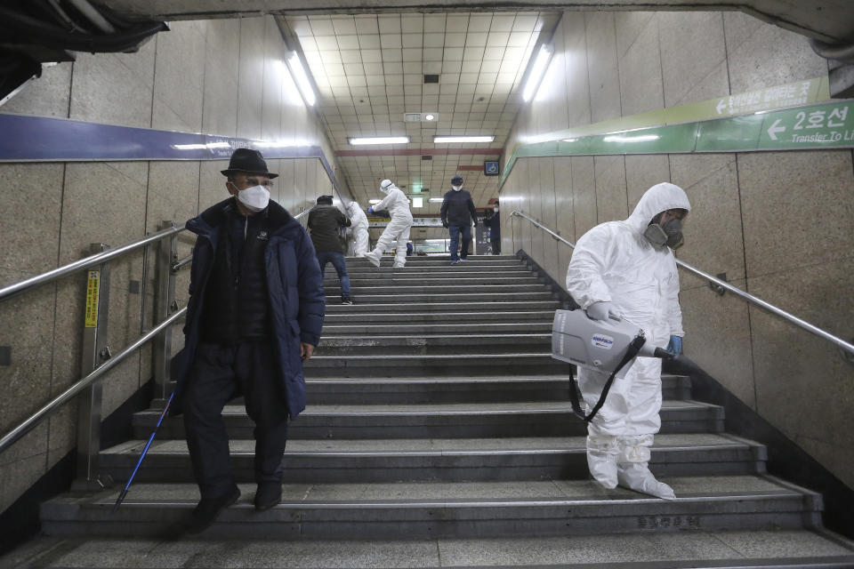 Workers wearing protective gears spray disinfectant as a precaution against the coronavirus at a subway station in Seoul, South Korea, Friday, Feb. 21, 2020. South Korea on Friday declared a "special management zone" around a southeastern city where a surging viral outbreak, largely linked to a church in Daegu, threatens to overwhelm the region's health system. (AP Photo/Ahn Young-joon)