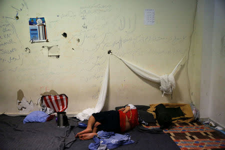 A boy sleeps inside the disused Hellenikon airport, where refugees and migrants are temporarily housed, in Athens, Greece, July 13, 2016. REUTERS/Alkis Konstantinidis/File Photo