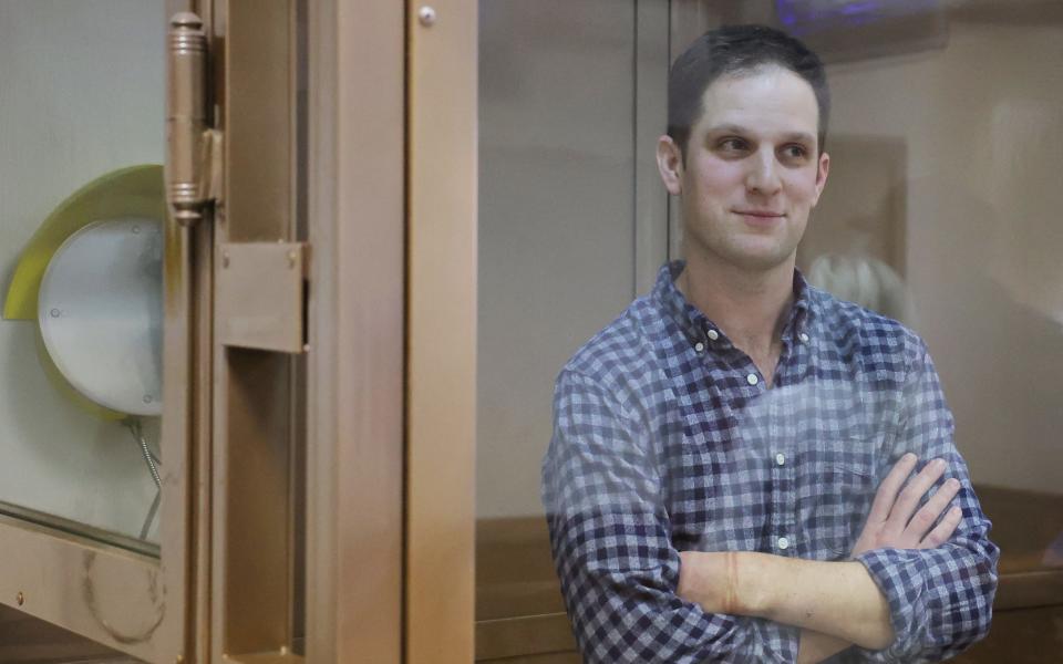 Wall Street Journal reporter Evan Gershkovich, who was detained in March while on a reporting trip and charged with espionage, stands behind a glass wall of an enclosure for defendants before a court hearing to consider an appeal against his detention, in Moscow, Russia - EVGENIA NOVOZHENINA/REUTERS