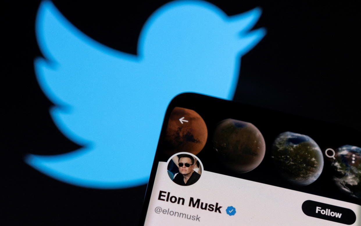 Elon Musk's twitter account is seen on a smartphone in front of the Twitter logo in this photo illustration taken, April 15, 2022. REUTERS/Dado Ruvic/Illustration