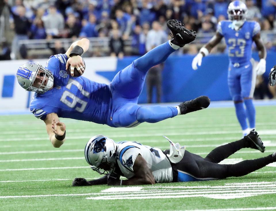 Lions defensive end Aidan Hutchinson is tackled by Panthers wide receiver Jonathan Mingo after his interception of a pass by Panthers quarterback Bryce Young during the first half of the Lions' 42-24 win on Sunday, Oct. 6 2023, at Ford Field.