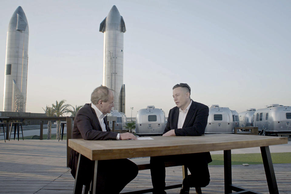 TIME's Kluger, left, interviews Musk; two Starships loom in the background