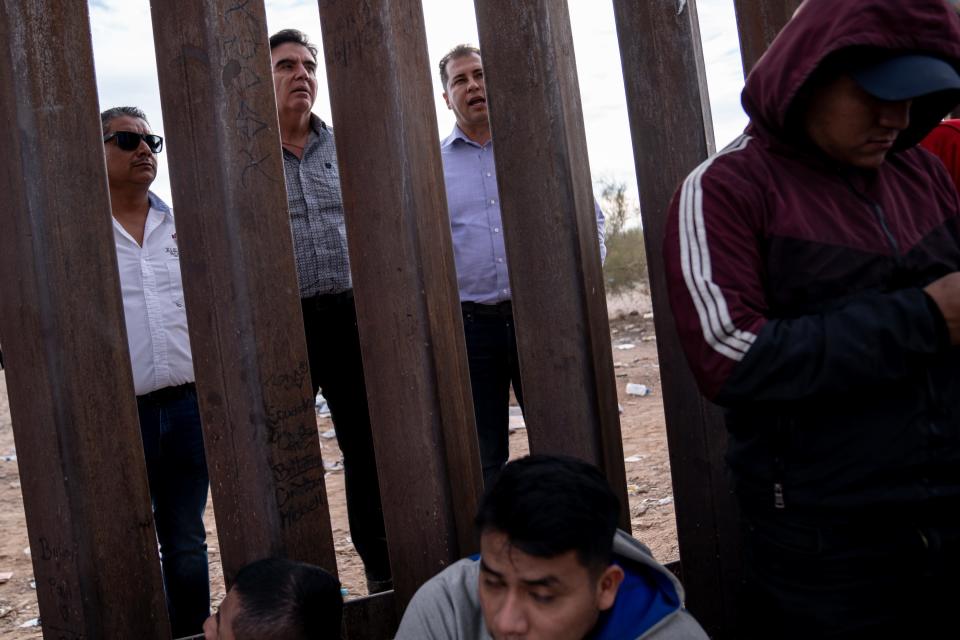 Mexican mayors Luis Enrique Valdez Reyes of Sonoyta, left, Abraham David Mier Nogales of Caborca, center, and Jorge Pivac of Puerto Peñasco are interviewed through the U.S.-Mexico border during a visit to see the situation of migrants and asylum seekers waiting to be picked up and processed by U.S. Border Patrol agents in Organ Pipe Cactus National Monument along the U.S.-Mexico border about a mile west of Lukeville, Ariz., on Dec. 4, 2023. The Lukeville Port of Entry was closed indefinitely by officials Dec. 4.