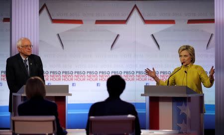 Democratic U.S. presidential candidate former Secretary of State Hillary Clinton speaks as Senator Bernie Sanders listens at the PBS NewsHour Democratic presidential candidates debate in Milwaukee, Wisconsin, February 11, 2016. REUTERS/Jim Young