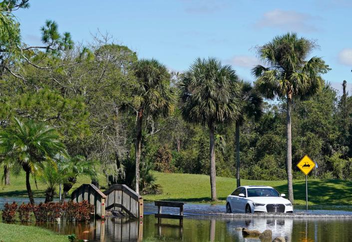 Some vehicles make their way through flooding water in Pelican Bay after flooding from tropical storm Ian in Daytona Beach, Friday, Sept.30, 2022.