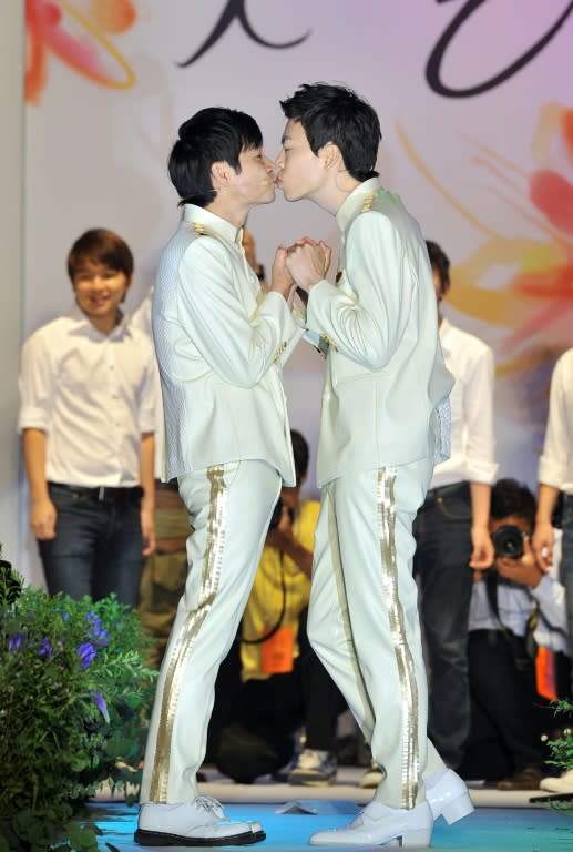 Film director Kim Jho Gwang-Soo (L) kisses his partner Kim Seung-Hwan during their wedding in central Seoul on September 7, 2013