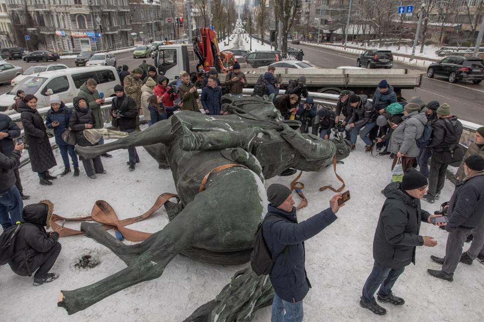 People gathered around the statue depicting Red Army commander Mykola Shchors after it was dismantled (Roman Pilipey/AFP via Getty Images)