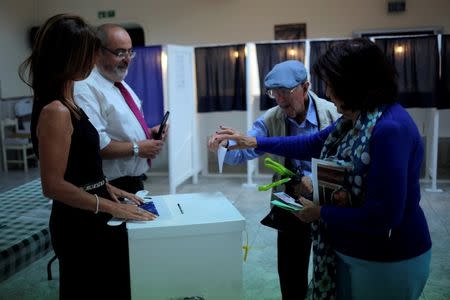 A woman helps to elderly man to cast his vote at a polling station during the EU referendum in the British overseas territory of Gibraltar, historically claimed by Spain, June 23, 2016. REUTERS/Jon Nazca