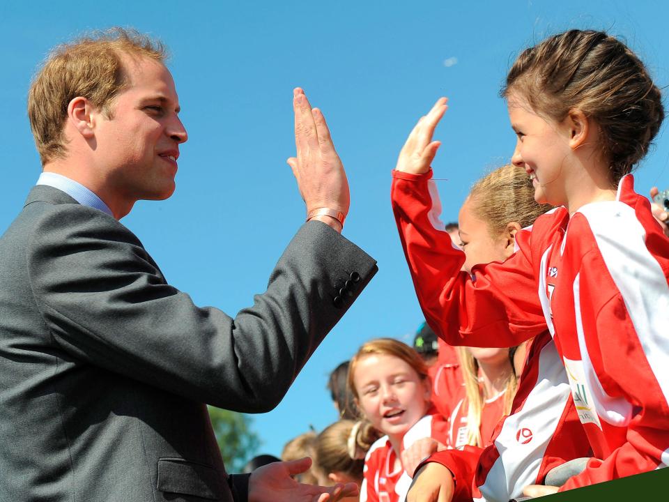Prince William high-fives a young girl