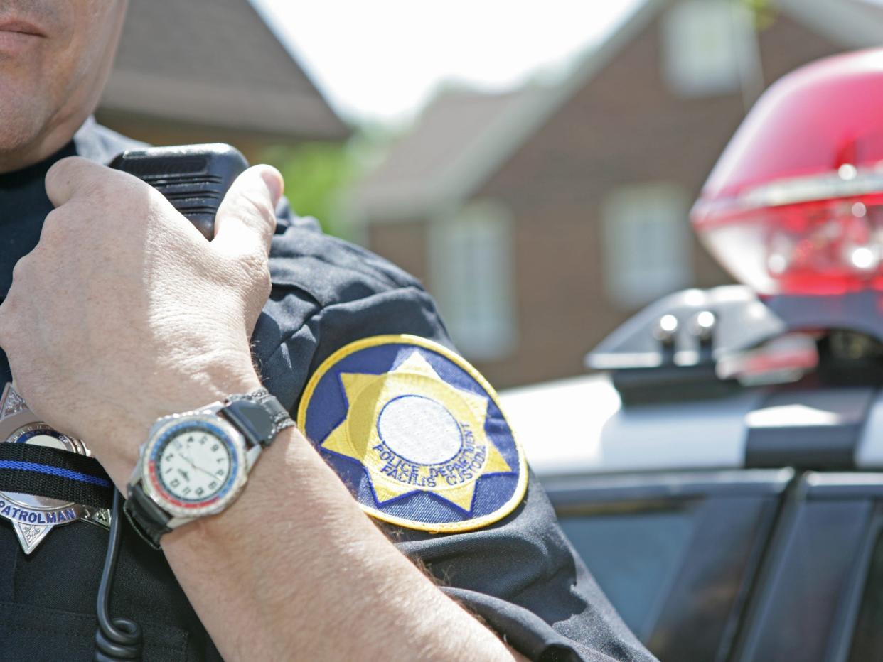 Police officer in front of police car