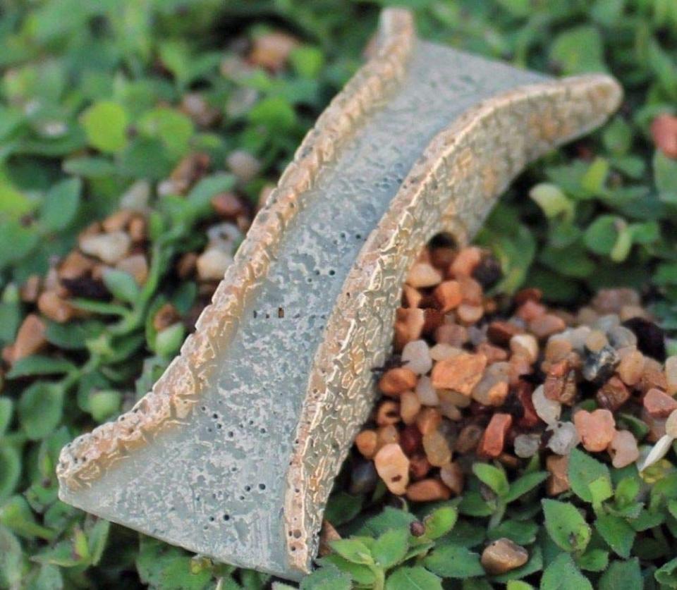 Miniature stone bridge figure for terrarium sitting over pebbles and small groundcover